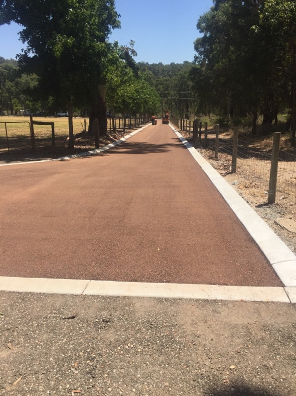 This is a photo of a hot spray & seal bitumen roadway which is in the process of being installed by Hurstbridge Surfacing Solutions